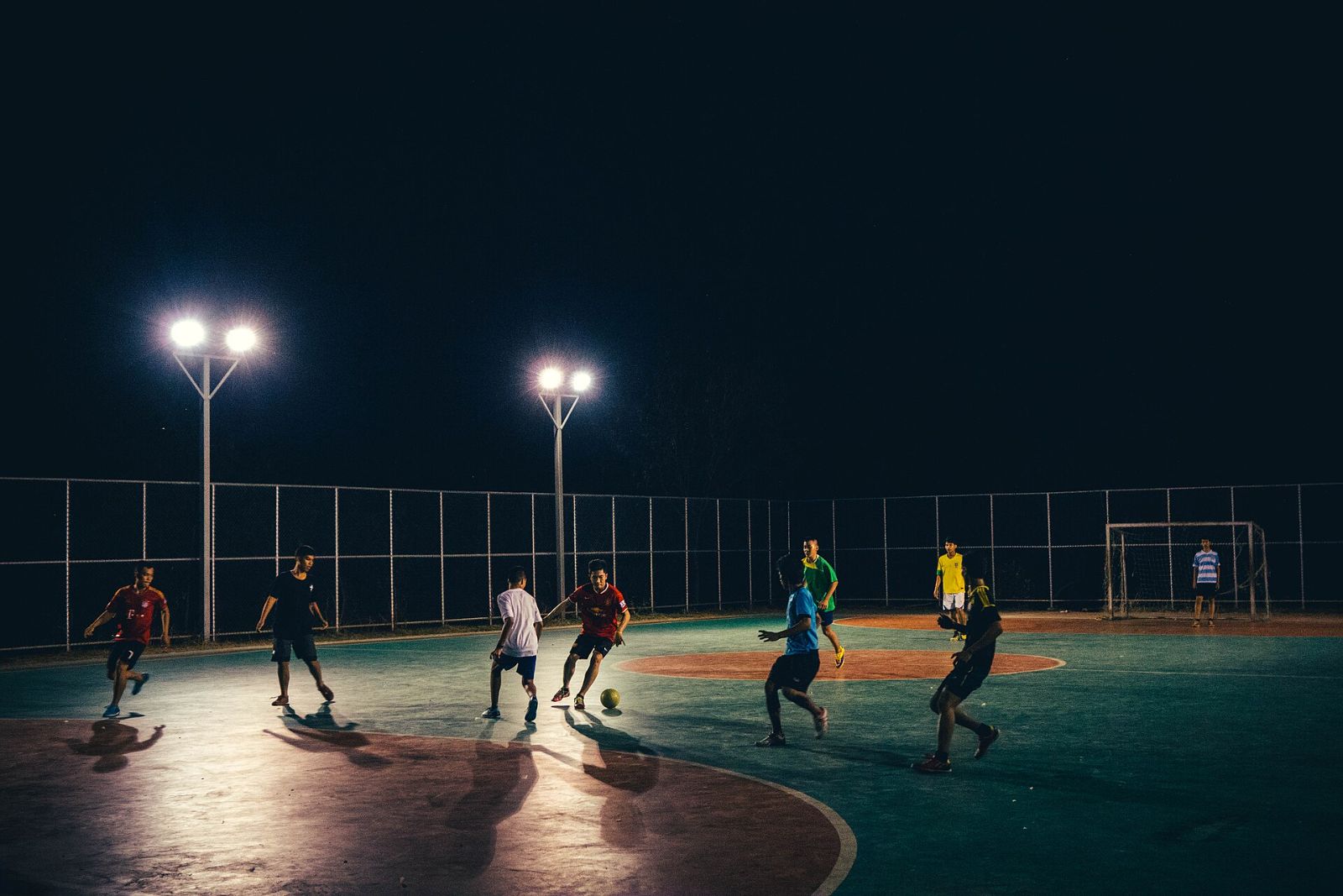 Players on a floodlit outdoor court at night